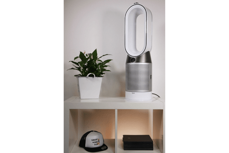The Dyson Pure Hot + Cool HP04 air purifier stands on a shelf next to a plant.
